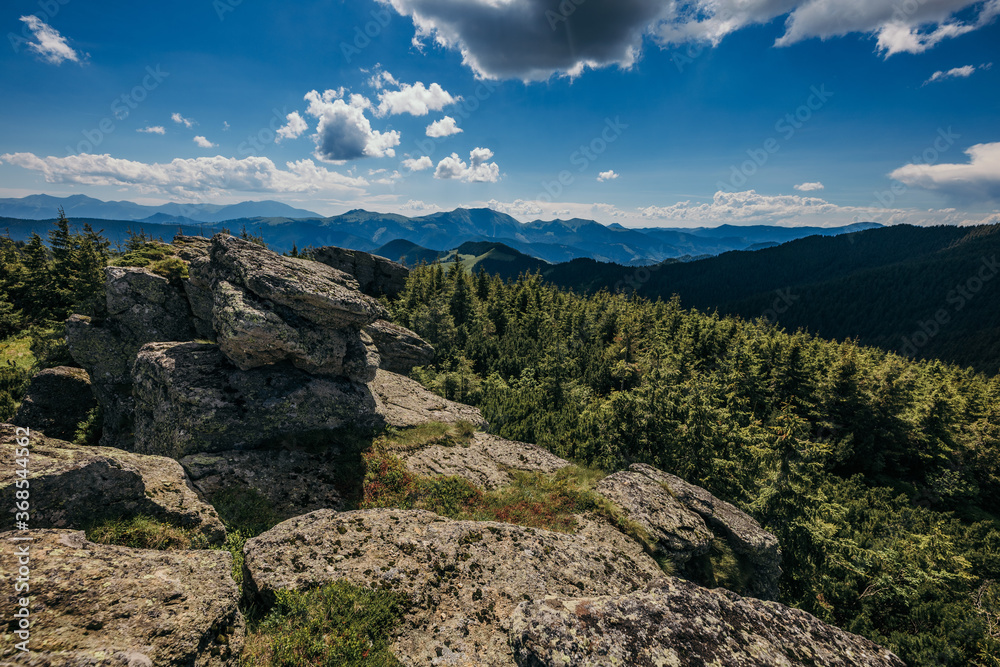 A herd of sheep standing on top of a rocky mountain