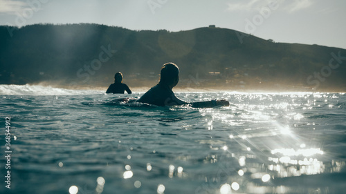 two surfer girls talking in the sea