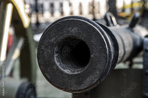 trunk of a heavy cast-iron gun close up, smooth-bore cannon