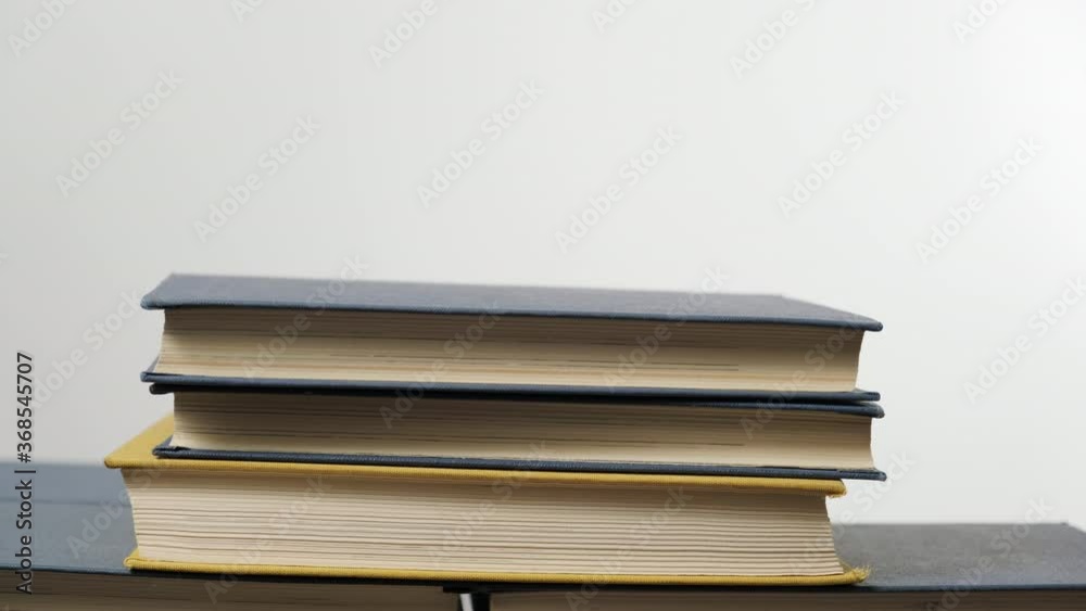stack of various hardback books, hand stacks books on top of each other on white background, reading concept stack of various hardback books, hand stacks books on top of each other on white background, reading concept