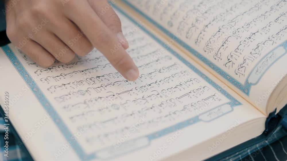 Asian muslim young man sitting reads a koran book, Study education of religious teachings