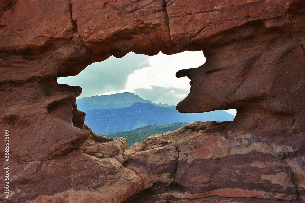 Blue sky threw the Window of the Siamese Twins in the Garden of the Gods with a view of Pikes Peak.