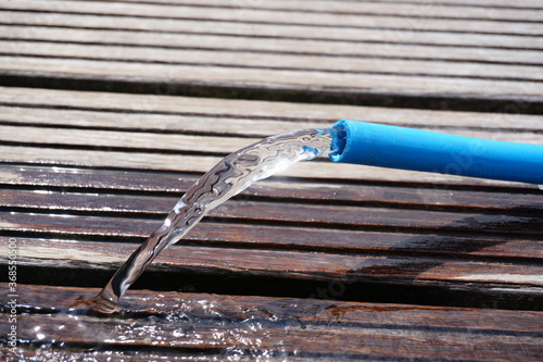 Close up of water hose where water comes out. Water wastage.