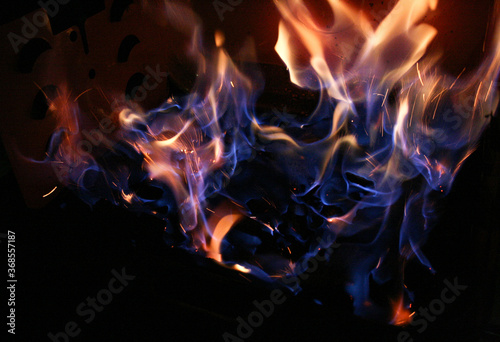 sparks of blue fire on coals in the night