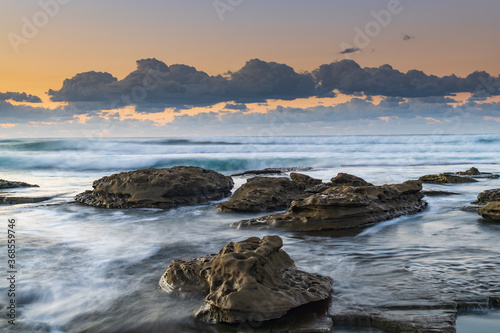 Sunrise Seascape with a low cloud bank and waves