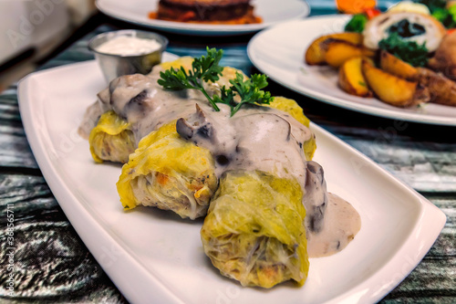 Obraz na płótnie Close up of cabbage rolls on a plate with mushroom cream sauce over them. w salonie
