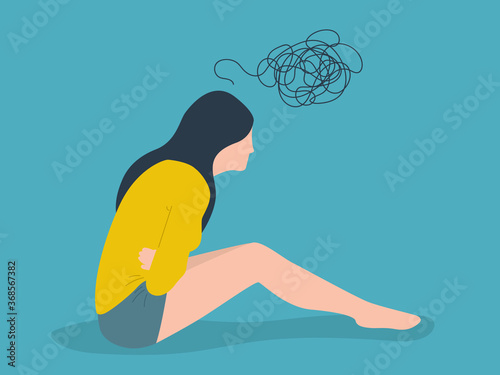 Young beautiful woman holding hurting belly suffering from cramp and period pain sitting on home sofa in painful face expression female menstruation concept. Lifestyle and health concept. photo