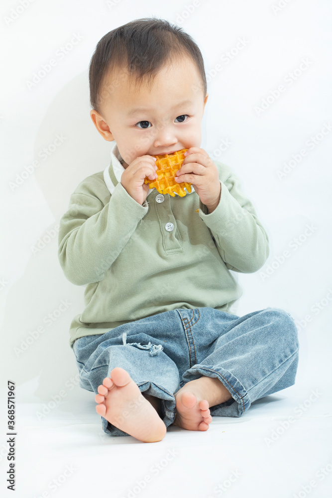 A cute two-year-old boy eats cookies A cute two-year-old boy eats cookies