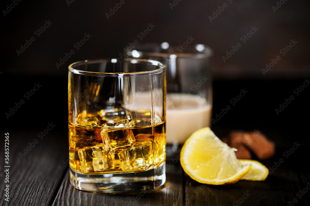 Whisky with ice and a lemon and creamy liqueur with chocolate Whisky with ice and a lemon and creamy liqueur with chocolate