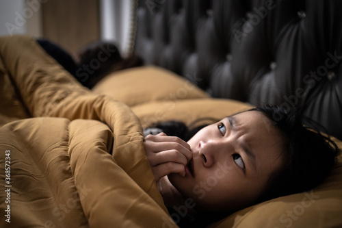 Frightened asian child girl is looking around and nail biting,stress,worry,feels scared,anxiety,hearing something haunting,symptoms of neurological,hallucination,not enough rest,Schizophrenia concept