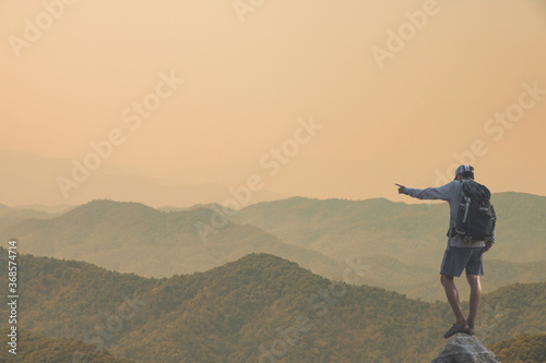 Young man standing on top of the mountain