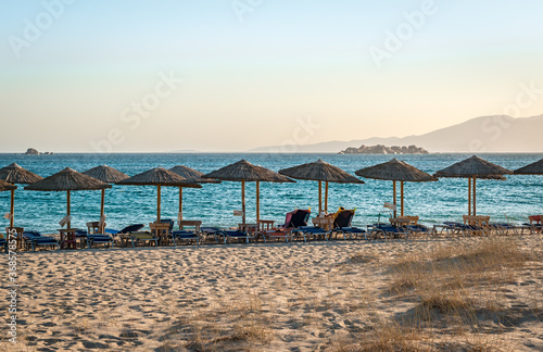 View of Plaka beach  with sunbeds and umbrellas  in the afternoon. Naxos island  Greece