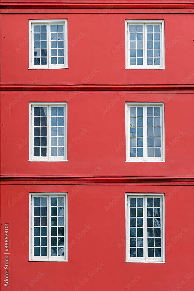 Six white windows on a red facade Six white windows on a red facade