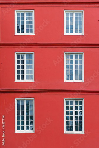 Six white windows on a red facade