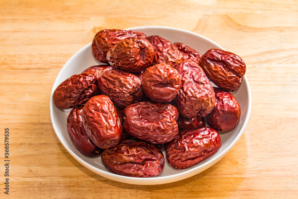 The bamboo dustpan is filled with bright red Xinjiang dates The bamboo dustpan is filled with bright red Xinjiang dates