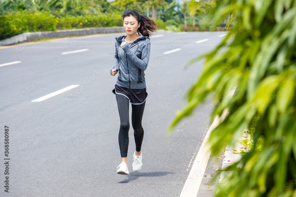 Young women run for fitness in the morning Young women run for fitness in the morning