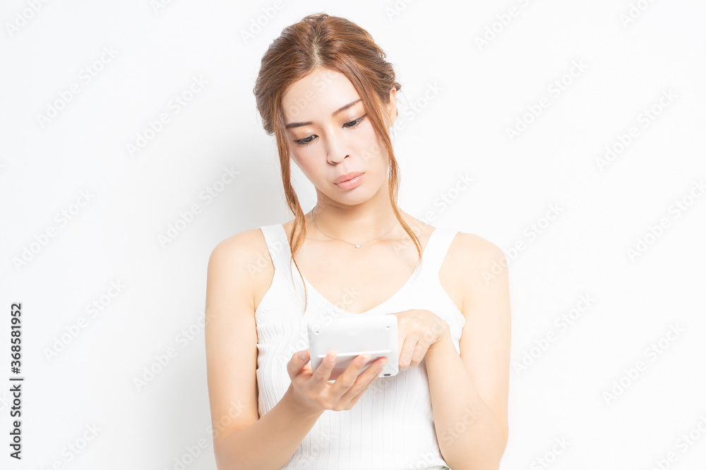 電卓を使う若い女性 電卓を使う若い女性