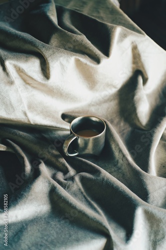 Morning coffee by the velvet bed sheet