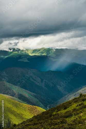 The green meadows on mountains in Tibet, China, summer time, on a cloudy day.