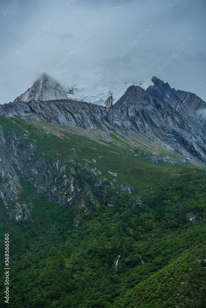 Close shot of the snow mountains in Yading, on a cloudy day, summer time.