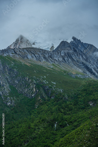 Close shot of the snow mountains in Yading, on a cloudy day, summer time.