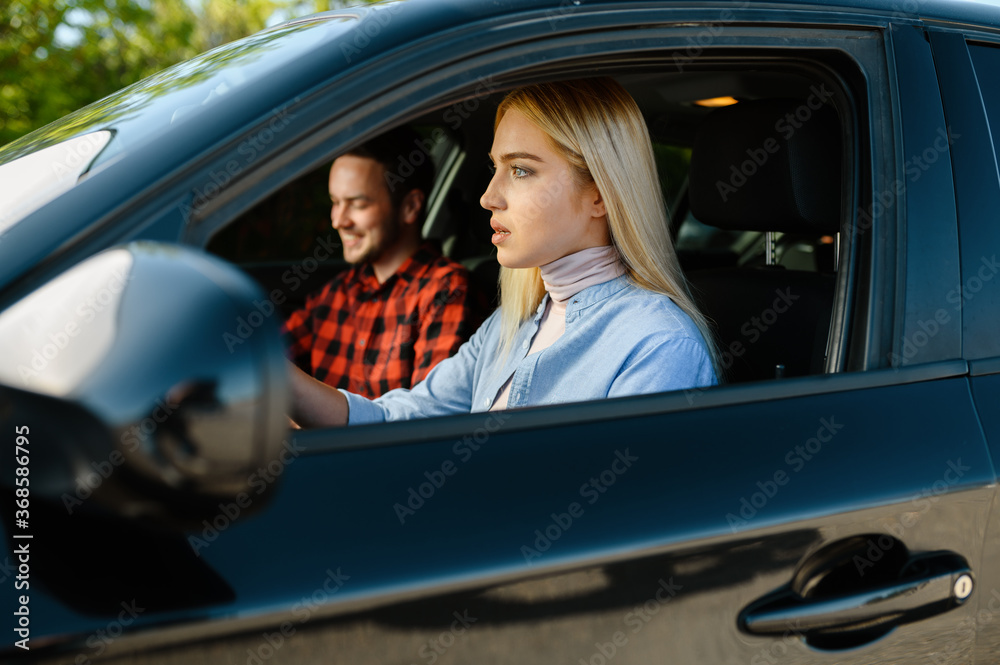 Student and male instructor in car, driving school