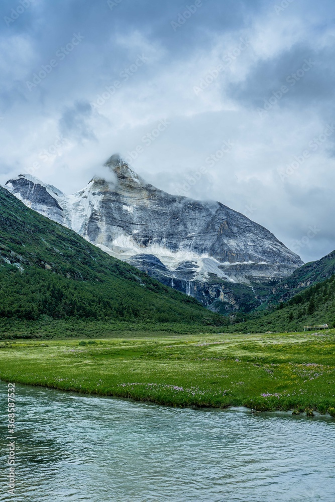 The creeks on meadows and snow mountains Yading, Sichuan province, China, on summer time, on a cloudy day.