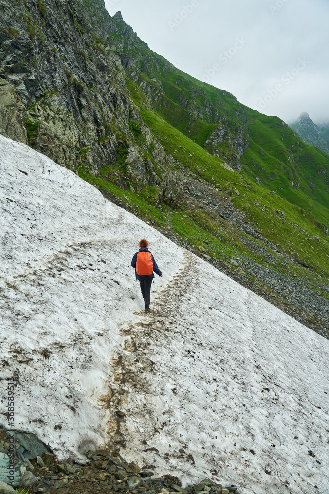 Woman hiker on a trail in the mountains
