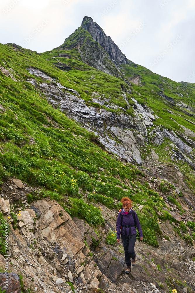 Woman hiker on a trail in the mountains