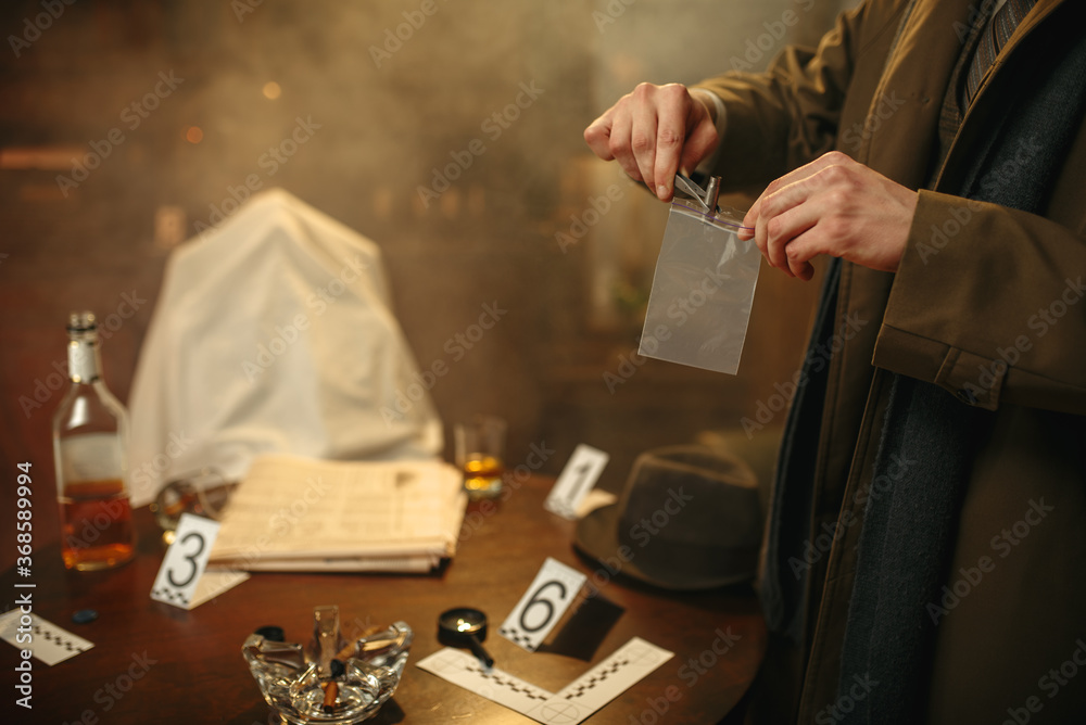 Obraz premium Detective with tweezers puts the evidence in a bag