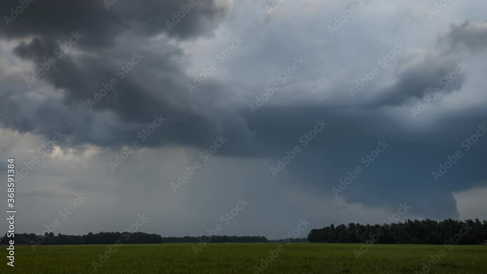 Time lapse of storm clouds moving over farmland grassland farming meadow field. Summer storm forming. Rain rainfall cloud motion day thunderstorm. Wide, zoom out, low angle Time lapse of storm clouds moving over farmland grassland farming meadow field. Summer storm forming. Rain rainfall cloud motion day thunderstorm. Wide, zoom out, low angle
