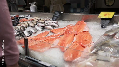 many raw fish on crushed ice bed in the fishmarket. Group of different fish, dorada and salmon on ice.