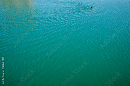 Unrecognisable man swiming in large body of water