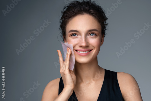 Billede på lærred Woman using facial oil blotting paper