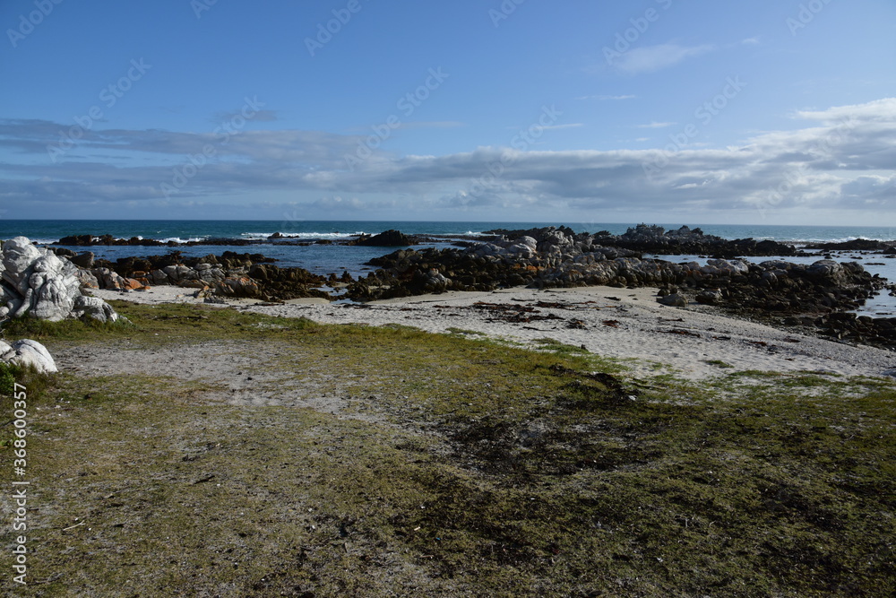 Sand, rocks, sea and clouds near Agulhas, where the Indian and Atlantic Oceans meet