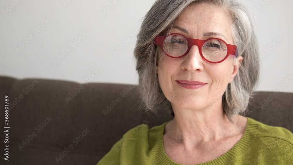 Happy wrinkled woman in eyeglasses smiling on cam, wrinkled skin, healthy ageing Happy wrinkled woman in eyeglasses smiling on cam, wrinkled skin, healthy ageing