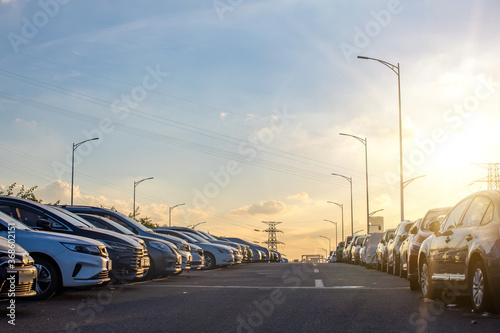 A roadside parking lot full of cars at sunset © Mulin
