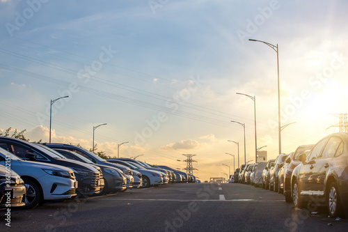 A roadside parking lot full of cars at sunset