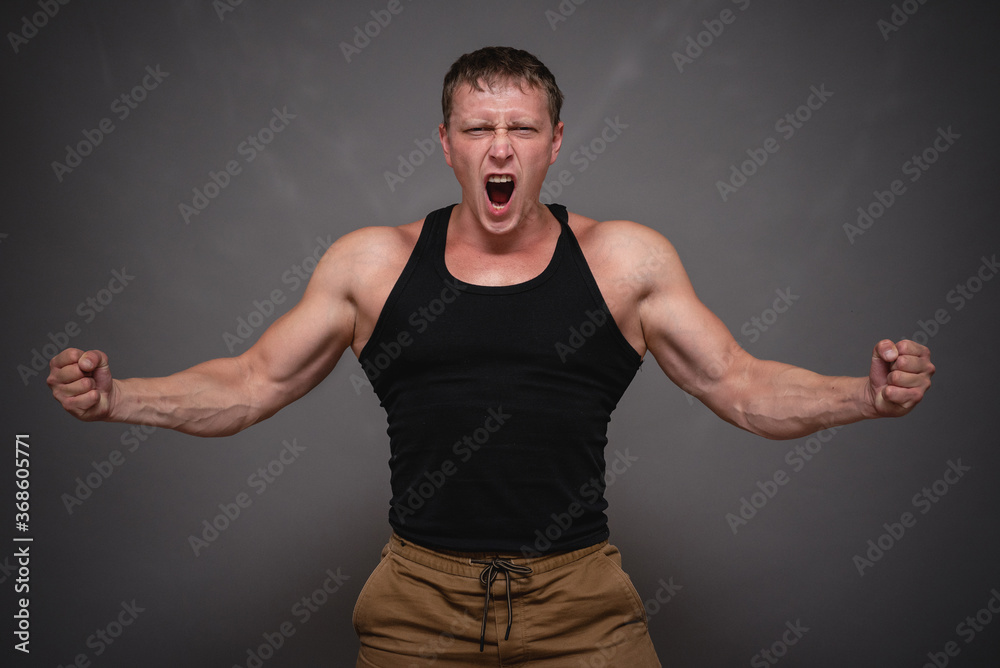 An angry man is yelling and shaking his fist on gray background. An angry man is yelling and shaking his fist on gray background.