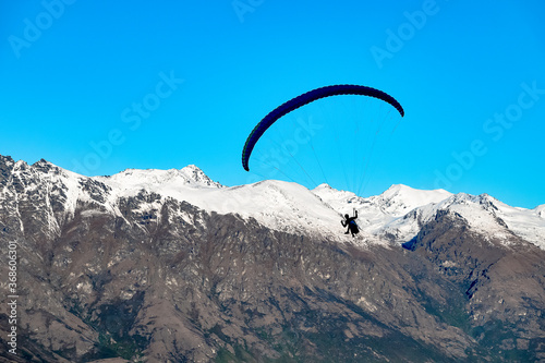 Paragliding in the alps of Queenstown, New Zealand. Remarcable ranges on the background.