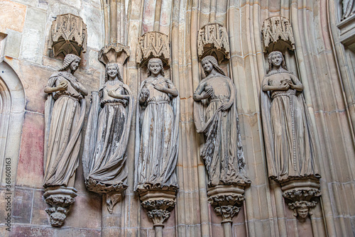 Canvas Print Ancient statues of young women dressed in mediaeval traditional clothes in inter