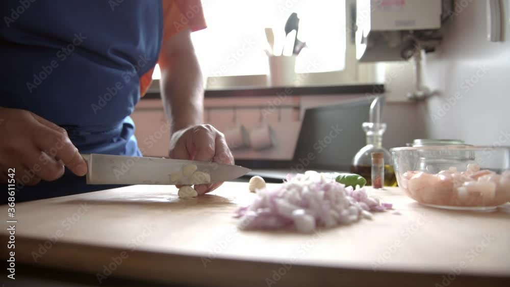 hands of a man in the kitchen chopping vegetables hands of a man in the kitchen chopping vegetables