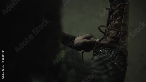Warrior wearing up his bracers. Camera perspective left to ride shoulder from back
