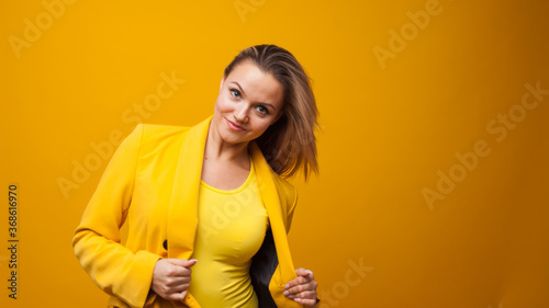 Stylish bright young woman dancing and rejoicing. The girl in the yellow jacket © Alexander