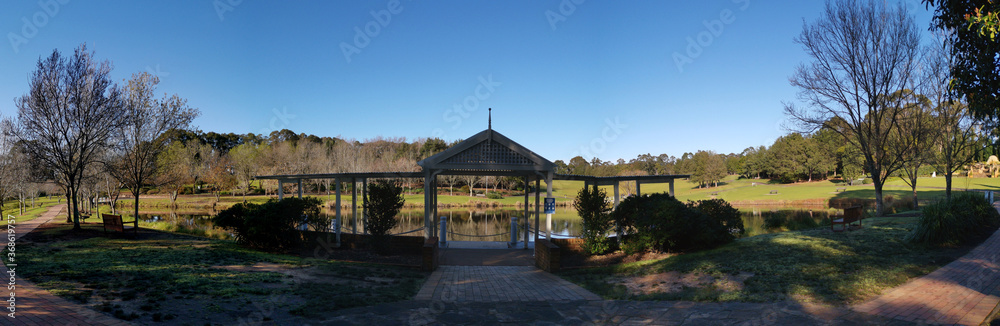 Beautiful morning view of a beautiful structure along the pond in a park with deep blue sky and tall trees, Fagan park, Galston, Sydney, New South Wales, Australia
