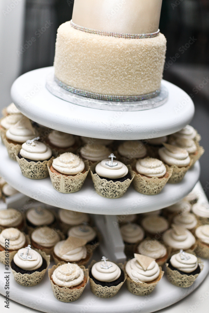 close up of wedding cake with cupcakes
