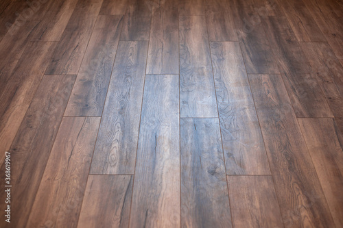 Laminate with a brown wood structure. Wood planks cover perspective background