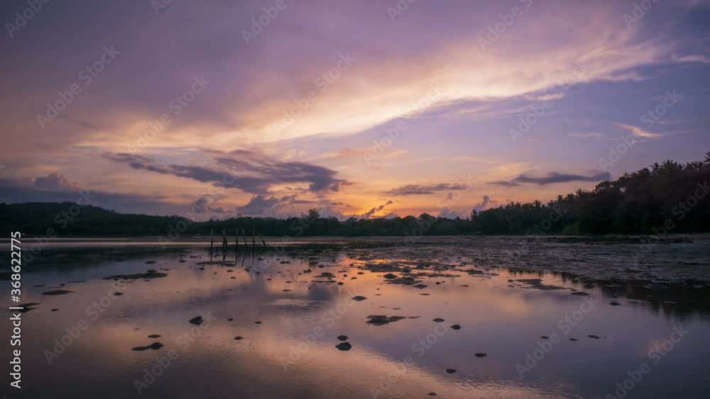 Timelapse : Bright sunset under the sea with waves splashes, dramatically clouds and beautifully reflective sunlight in water. UHD 4K 3840x2610 