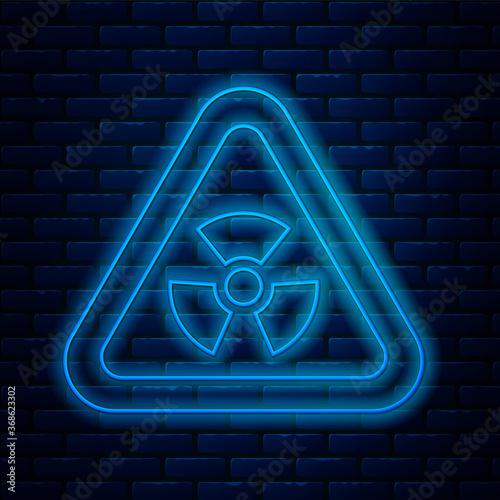 Glowing neon line Triangle sign with radiation symbol icon isolated on brick wall background. Vector.