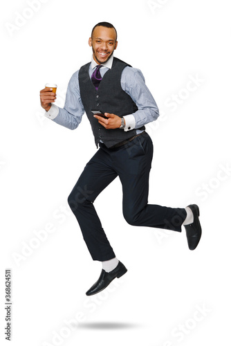 happy young african businessman jumping high and holding coffee to go and phone isolated on white background © Anatoly Repin